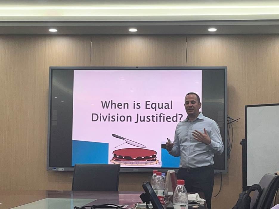 A person standing in front of a large screenDescription automatically generated A person standing in front of a large screenDescription automatically generated